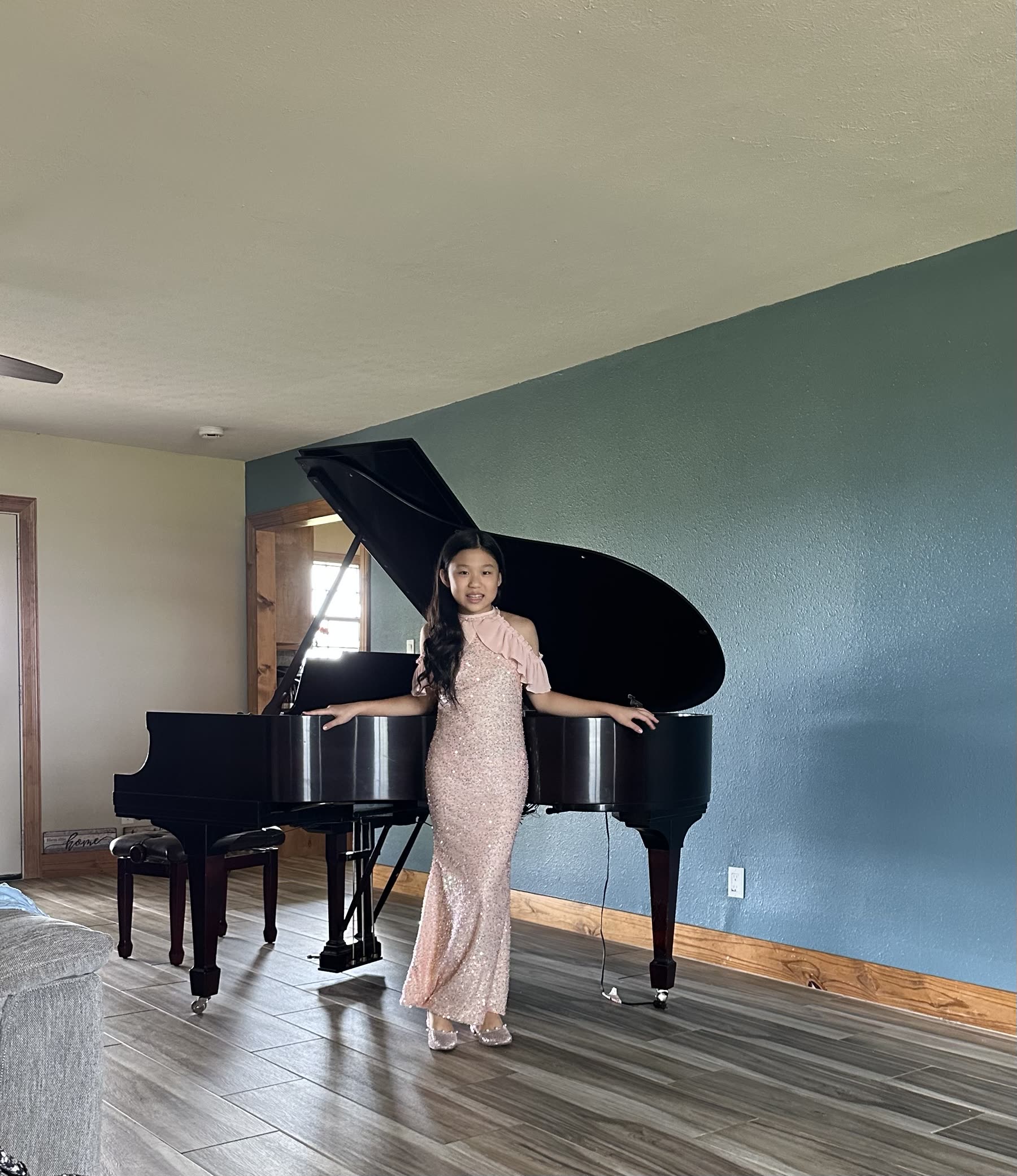 Victoria in a blush gown beside a grand piano