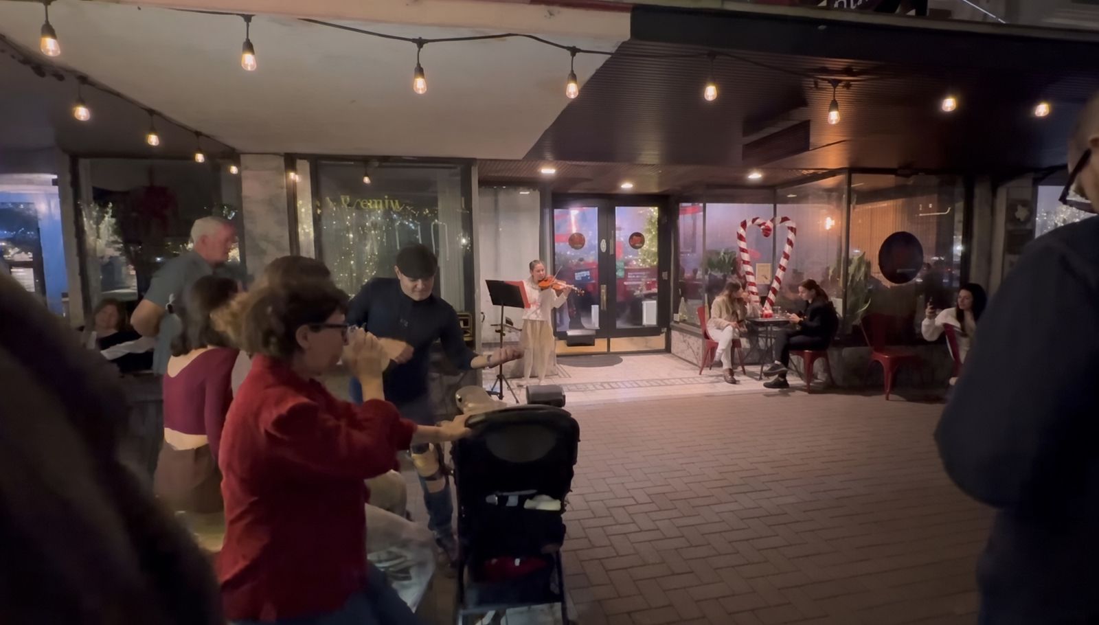 Evening violin performance outside a downtown cafe