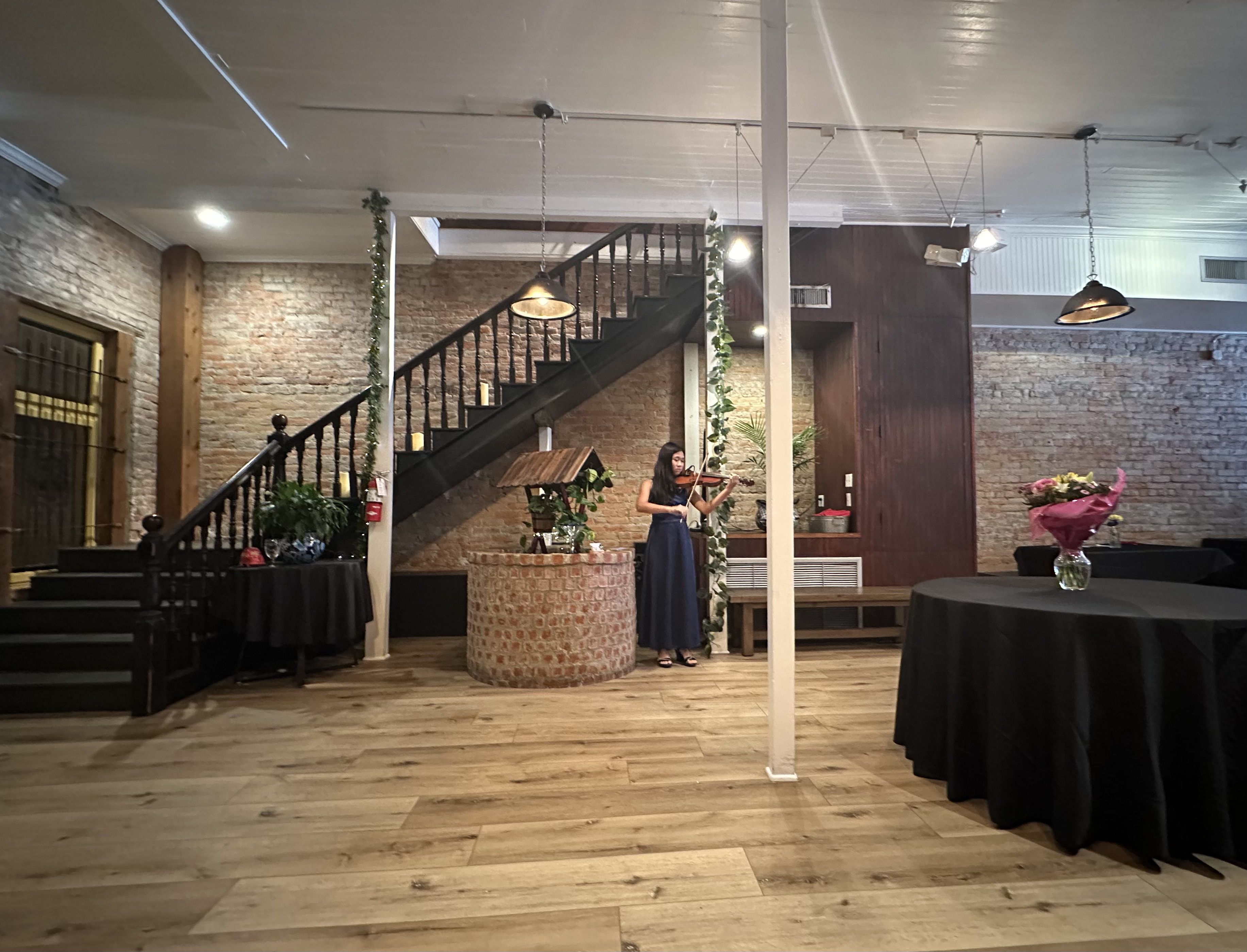 Victoria playing violin in an elegant brick venue